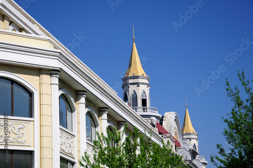 The exterior of a building with a gold roof on Zhongyang street in harbin China located in Heilongjiang province on a sunny blue sky day. photo