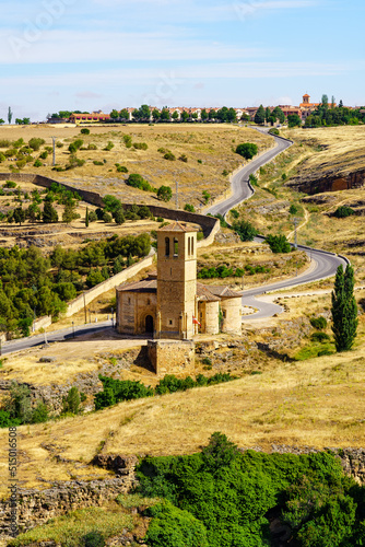 Medieval church on the outskirts of the city of Segovia with access road that goes up the hill.