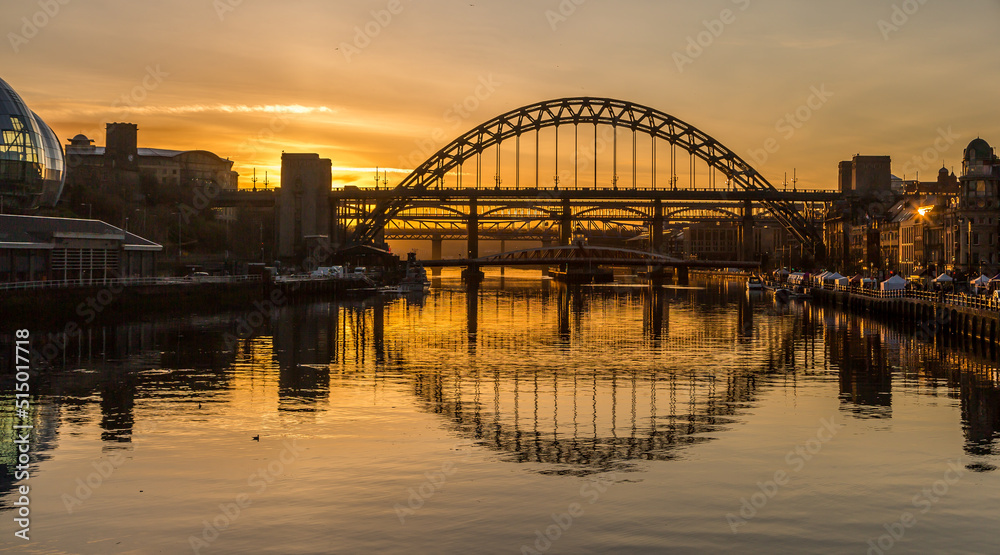 The Tyne Bridge in Newcastle at sunset, reflecting in the almost still River Tyne beneath