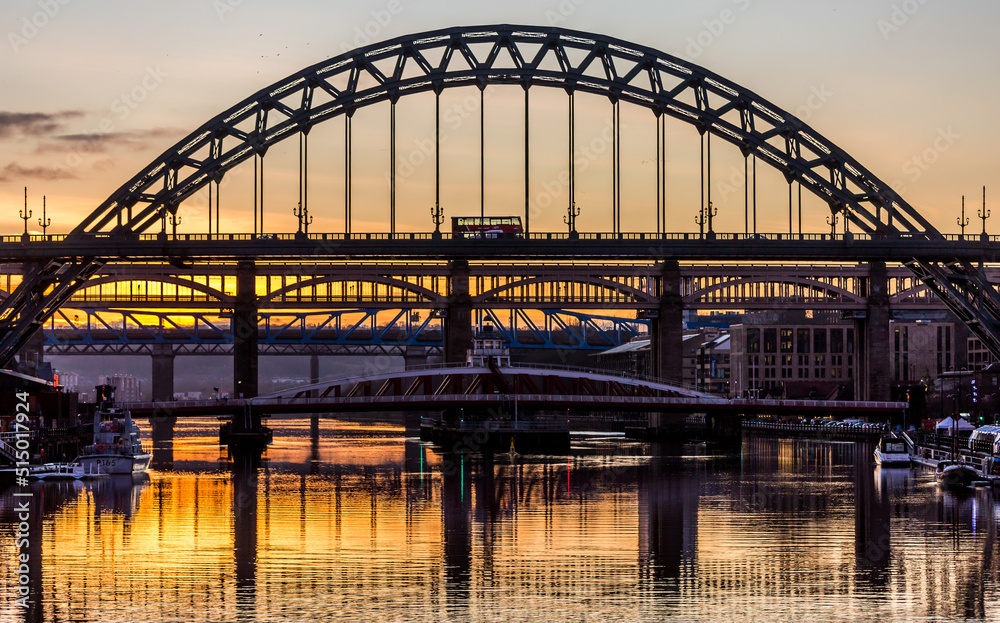 The Tyne Bridge in Newcastle at sunset, reflecting in the almost still River Tyne beneath