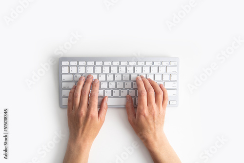 Female hands on the keyboard on a white background. Top view, flat lay photo