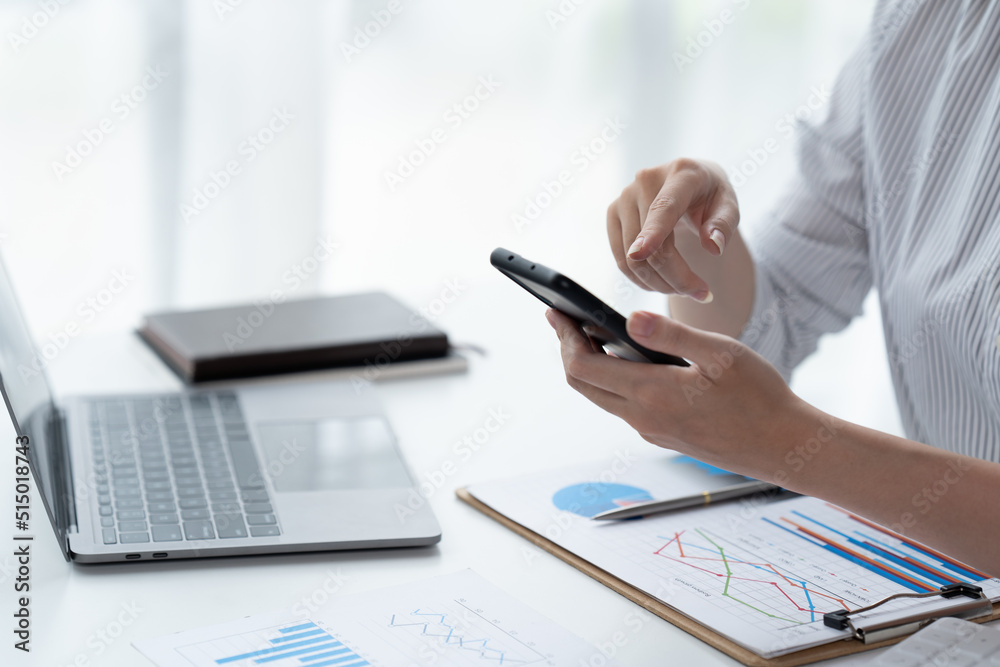 Fototapeta premium Asian businesswoman in formal suit in office happy and cheerful during using smartphone and working.