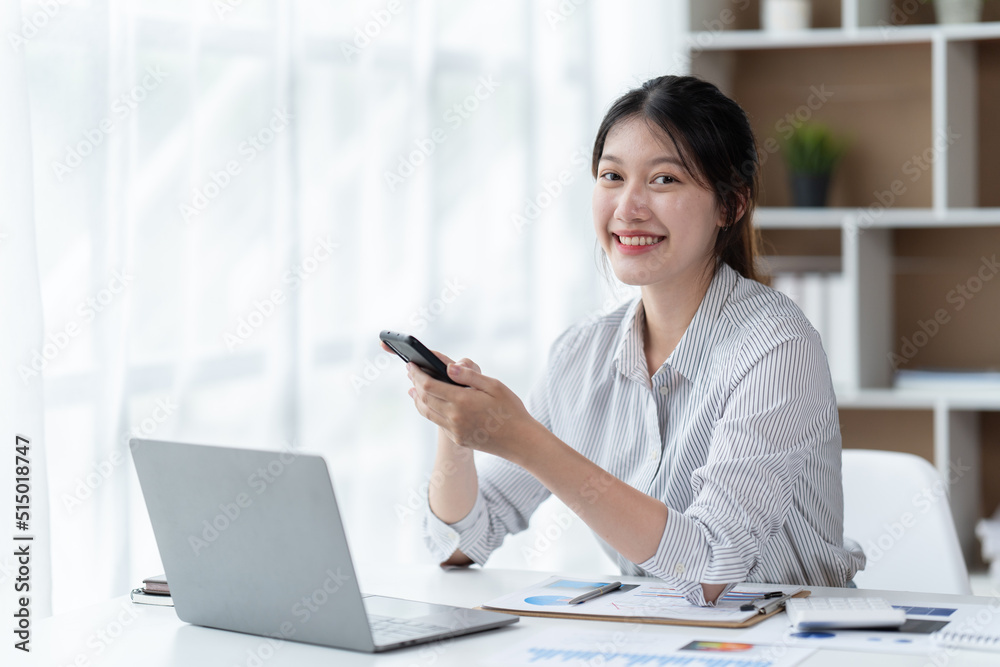 Asian businesswoman in formal suit in office happy and cheerful during using smartphone and working. Asian businesswoman in formal suit in office happy and cheerful during using smartphone and working.