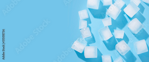 Many large ice cubes on a blue background. Top view, flat lay. Banner