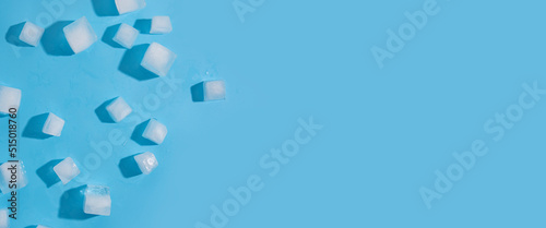 Many ice cubes on a blue background. Top view, flat lay. Banner