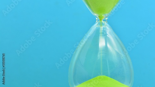 Detalle de un reloj de arena verde contando el tiempo photo
