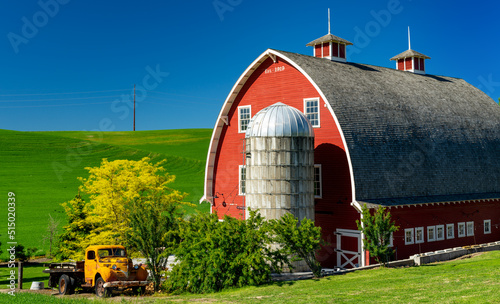 Red barn and yellow truck on a family farm photo