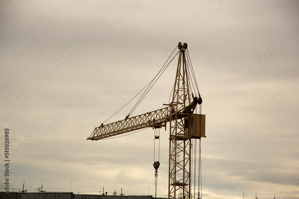Cranes and building construction. Construction crane at sunset