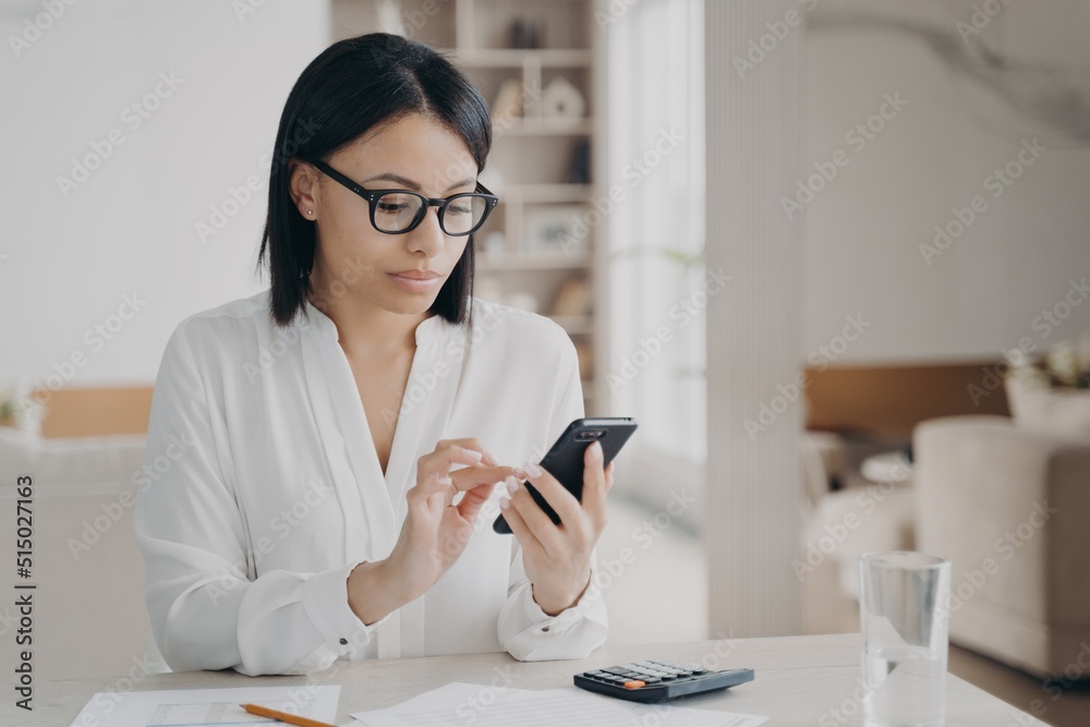 Business lady is appointing meeting, texting on smartphone. Manager or secretary at workplace..