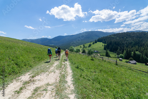 A group of tourists with backpacks moves through a valley in the Ukrainian Carpathians © Andrii Marushchynets
