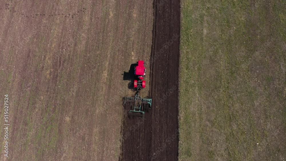 Red tractor working at field Red tractor working at field