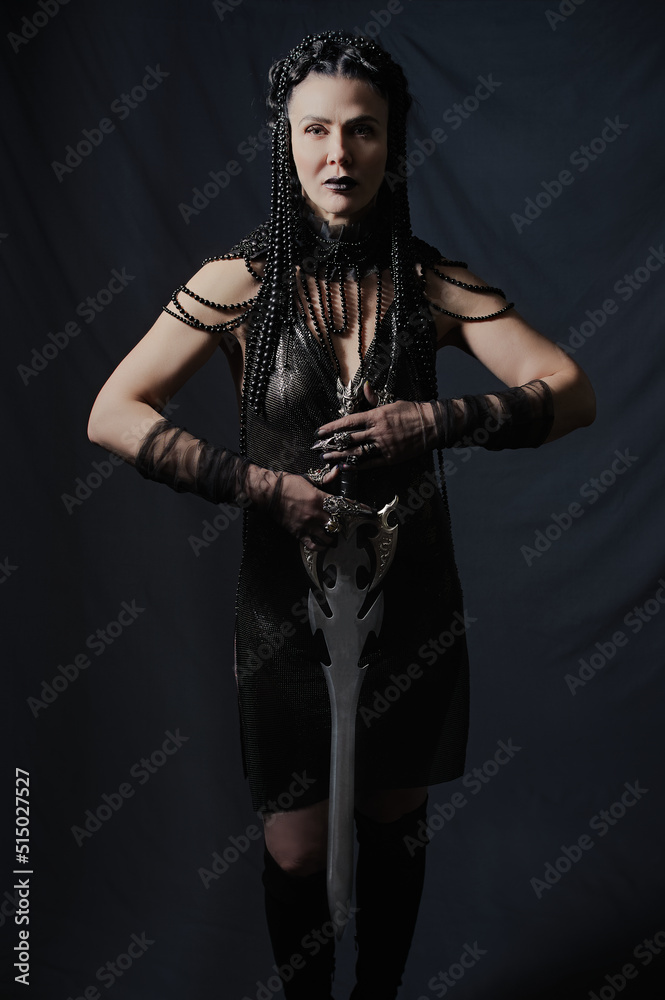 dramatic portrait of a female warrior with a sword.