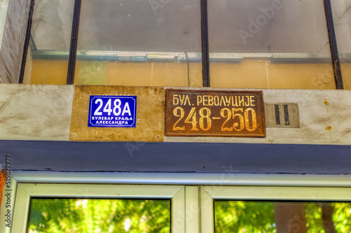 Old and new street name and house number plates in Belgrade, Serbia.