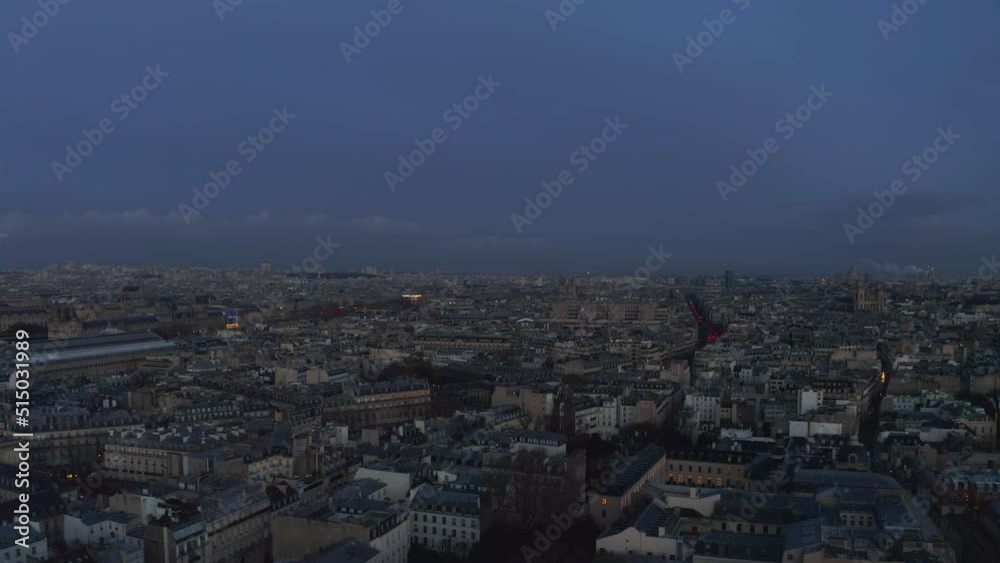 Forwards fly above buildings in urban borough. Town development in large city after sunset. Paris, France Forwards fly above buildings in urban borough. Town development in large city after sunset. Paris, France