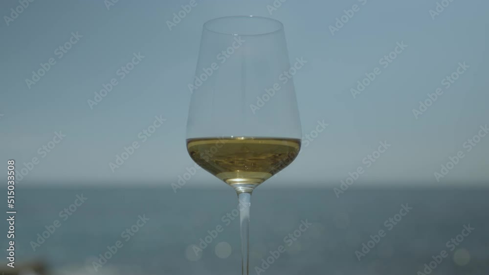 White wine in glass against the sea White wine in glass against the sea