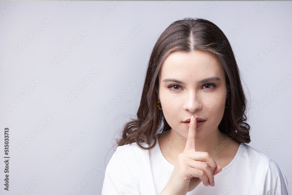 the young woman indicates with a hand gesture to be quieter