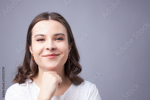 A young woman in a light-coloured blouse smiling, a beautiful smile