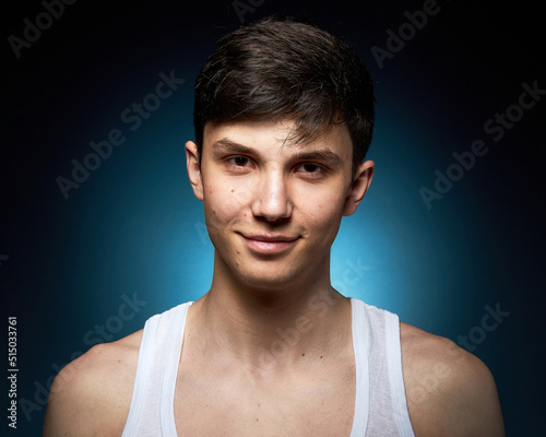 Portrait of a beautiful boy on a black background. Portrait of a young caucasian man. Attractive teenager..