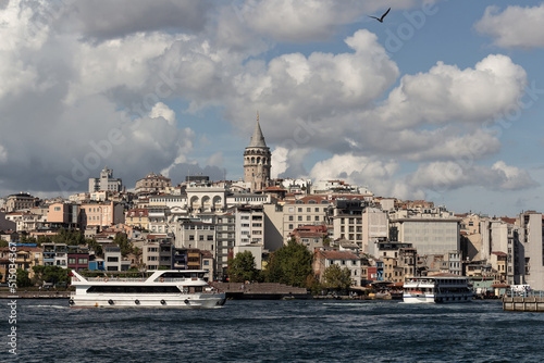 View of tour boats on Golden Horn area of Bosphorus in Istanbul. Galata tower and Beyoglu district are in the background. It is a sunny summer day.