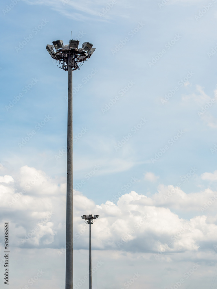 Two sport light stands out on a blue sky background.Lighting for road poles, electric industry, stadium or sports lighting. Two sport light stands out on a blue sky background.Lighting for road poles, electric industry, stadium or sports lighting.