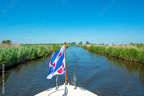 Cruising through National Park Alde Feanen in Friesland the Netherlands with the frisian flag