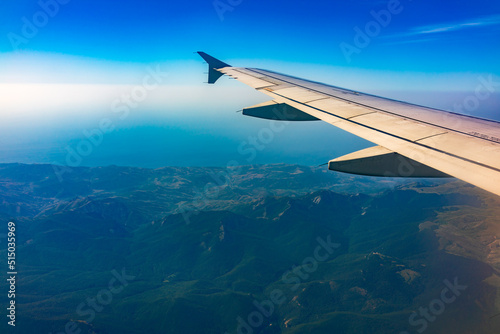 View from the airplane window at a beautiful blue clear sky and the airplane wing