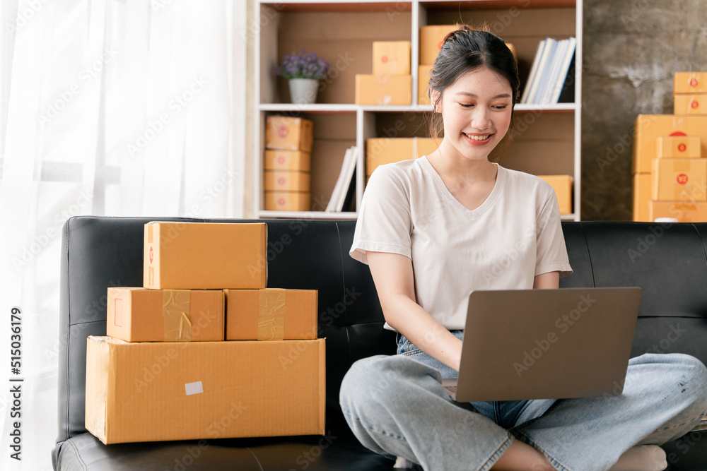 Portrait of a small business startup, SME owner, female entrepreneur, working, unboxing, checking orders online. To prepare to pack boxes for sale to SME customers online business ideas Portrait of a small business startup, SME owner, female entrepreneur, working, unboxing, checking orders online. To prepare to pack boxes for sale to SME customers online business ideas