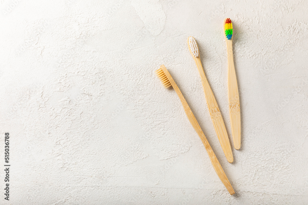 Eco friendly bamboo toothbrush on gray cement background. The concept of cosmetic products for the bathroom from natural organic products. Flat lay, top view, copy space. Oral care. Eco-friendly Eco friendly bamboo toothbrush on gray cement background. The concept of cosmetic products for the bathroom from natural organic products. Flat lay, top view, copy space. Oral care. Eco-friendly