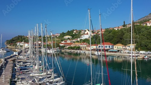 Small marina with catamaran yachts and sailboats in Greece. Kalamos Marina. Beautiful and cozy harbor in Greece. Old fishing village with port on the shore of the Ionian Sea. Travel by boat on the sea photo