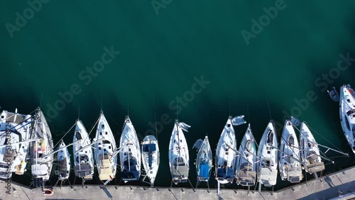 Small marina with catamaran yachts and sailboats in Greece. Kalamos Marina. Beautiful and cozy harbor in Greece. Old fishing village with port on the shore of the Ionian Sea. Travel by boat on the sea photo