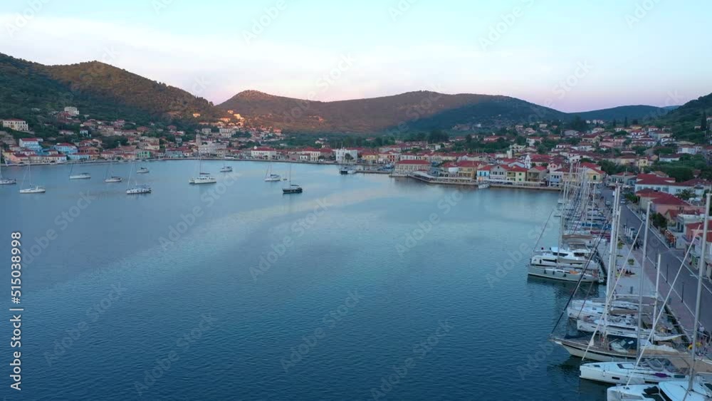 Vathy harbor with sailboats and catamarans anchored on the shore of the village of Ithaca Greece. Small marina Limani Vathy with a small island at the entrance. Sunset over the harbour. Beautiful Sea Vathy harbor with sailboats and catamarans anchored on the shore of the village of Ithaca Greece. Small marina Limani Vathy with a small island at the entrance. Sunset over the harbour. Beautiful Sea
