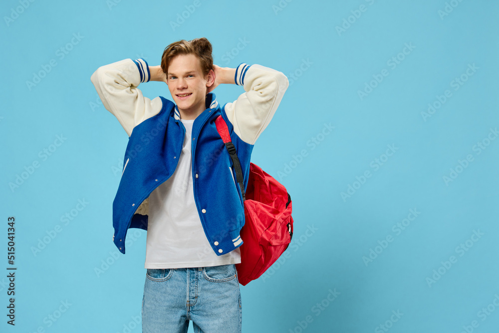 young man in a bomber jacket posing holding his hands behind his head