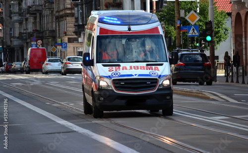 Karetka medyczna ratunkowa na sygnale jedzie ulicą miasta z pomocą do wypadku. 