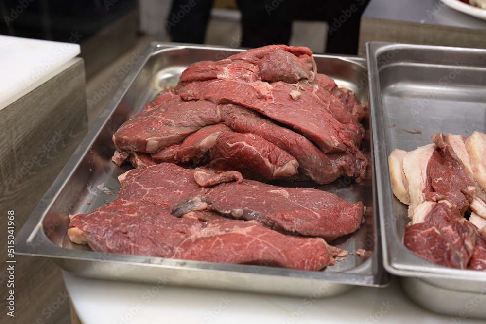 Large Steaks of Raw Beef Arranged on a Steel Pan Before Cooking
