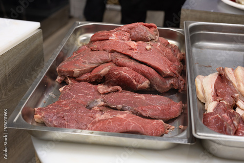 Large Steaks of Raw Beef Arranged on a Steel Pan Before Cooking