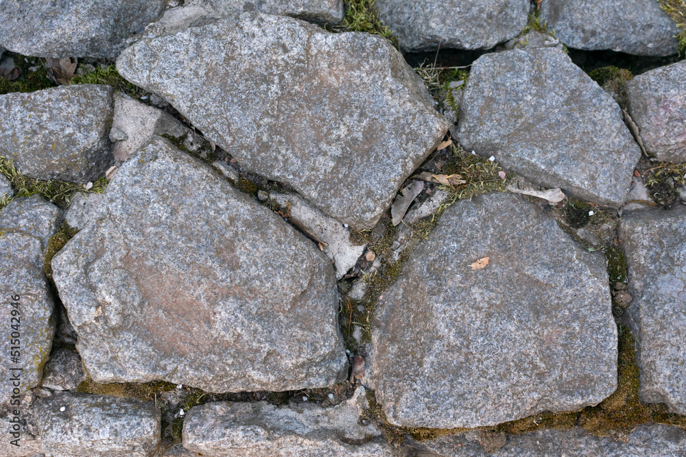 Road from large dark stones of cobblestones underfoot, texture, background