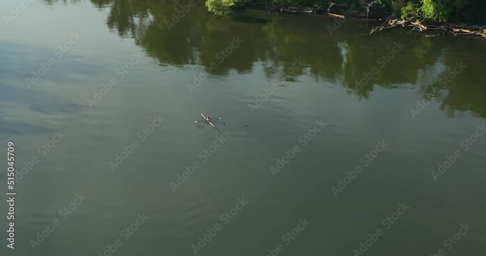 Ithaca NY USA June 26, 2022: Single rowing scull enjoying an early morning workout on the Cayuga Inlet near Ithaca New York, Cayuga Lake. Ithaca NY USA June 26, 2022: Single rowing scull enjoying an early morning workout on the Cayuga Inlet near Ithaca New York, Cayuga Lake.