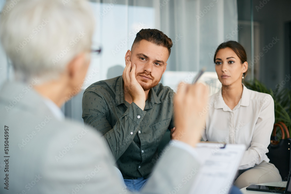 Young couple having marriage counseling with their therapist in the office. Young couple having marriage counseling with their therapist in the office.