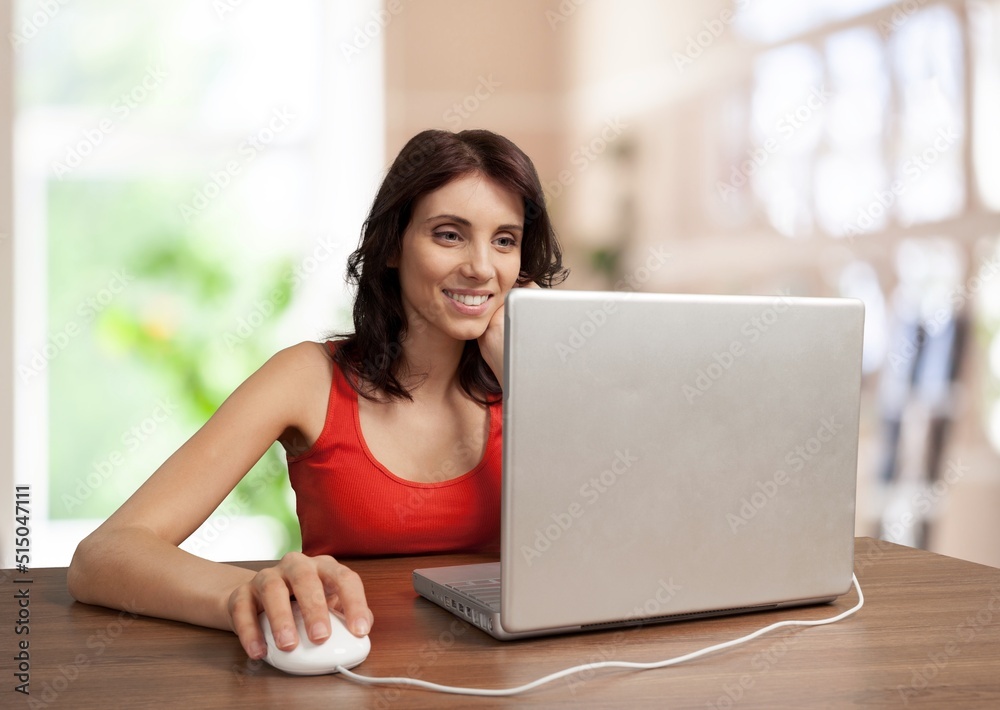 Happy young woman student learning at home looking at laptop computer watching online webinar, having virtual work meeting Happy young woman student learning at home looking at laptop computer watching online webinar, having virtual work meeting