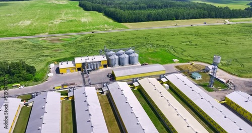 aerial view and circular votion around silos and agro-industrial livestock complex on agro-processing and manufacturing plant with modern granary elevator. chicken farm. rows of chicken coop