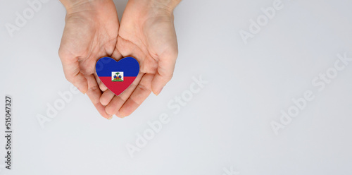 Εκτύπωση καμβά The national flag of Haiti of arms in female hands