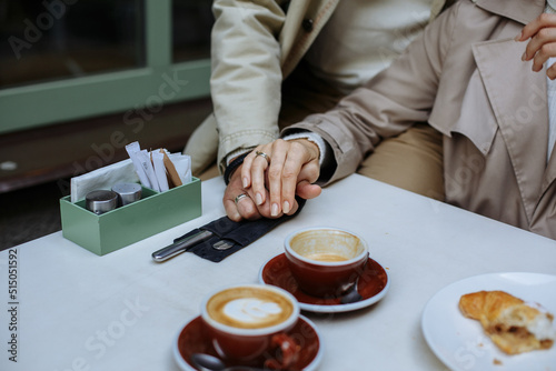 Couple in love holding hands. Dressed in light tones.