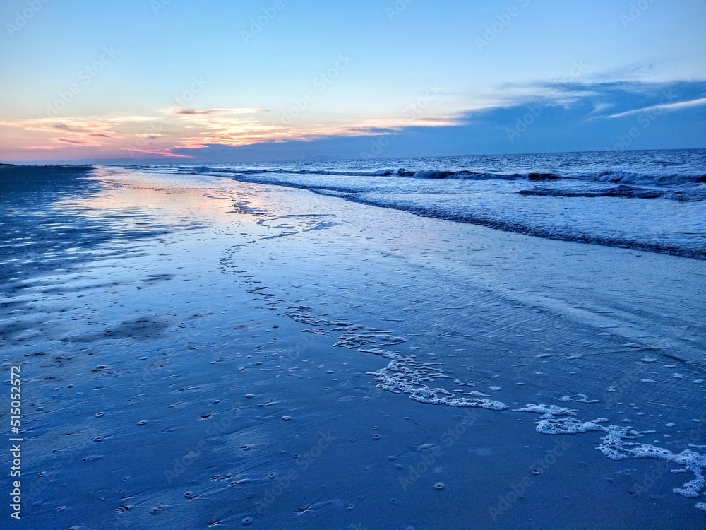 Blue Beach Ocean Sunrise Over Reflecting Traced Foam and Waves Blue Beach Ocean Sunrise Over Reflecting Traced Foam and Waves
