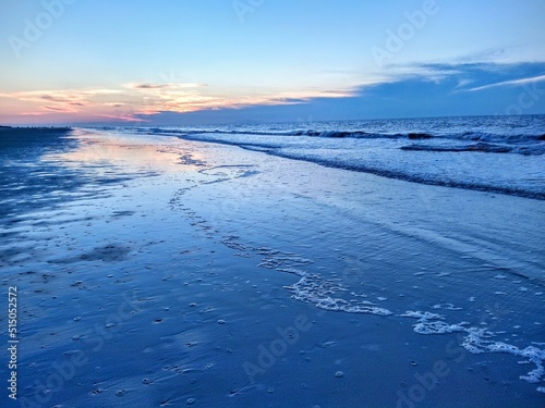 Blue Beach Ocean Sunrise Over Reflecting Traced Foam and Waves