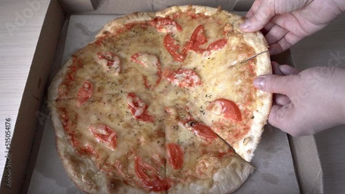 Slice of hot pepperoni pizza. Human hand taking pieces slices of hot tasty italian pizza from open box, food delivery
