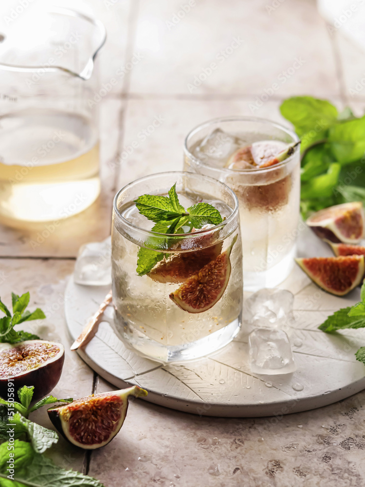 Fig iced cocktail with mint on tile background. Summer party concept Fig iced cocktail with mint on tile background. Summer party concept