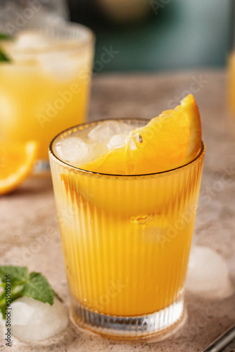 Orange and mint cocktail with metal straw, close up, summer soft drinks concept