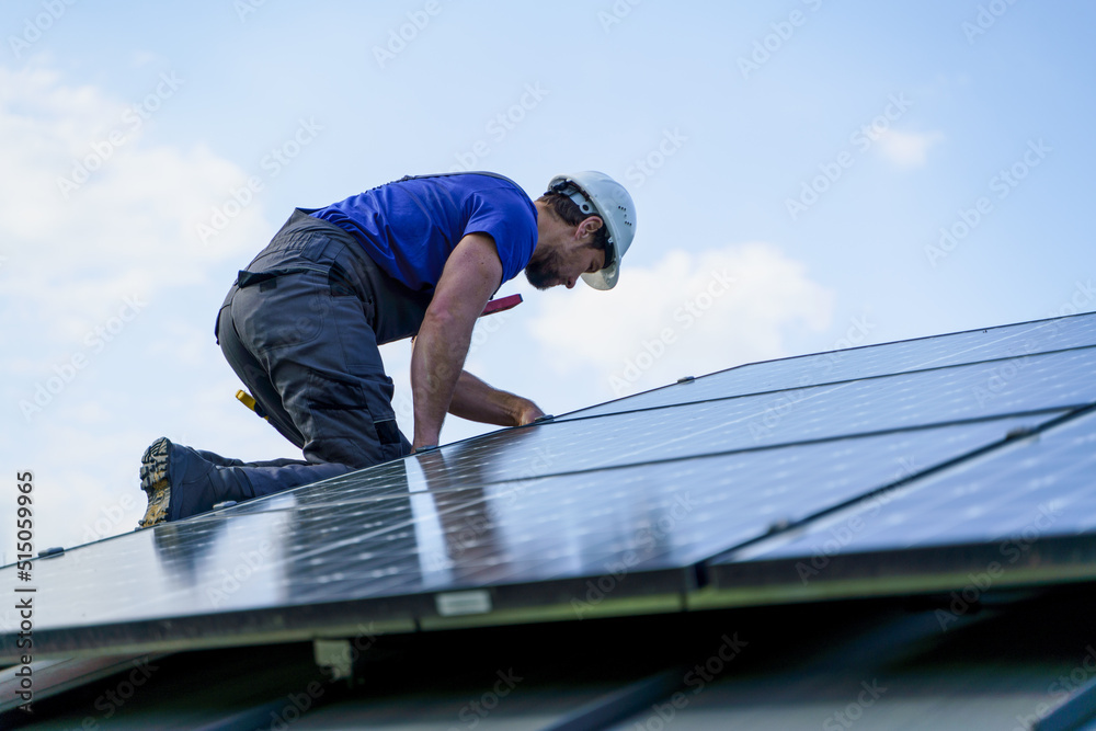 Man worker installing solar photovoltaic panels on roof, alternative energy concept. Man worker installing solar photovoltaic panels on roof, alternative energy concept.