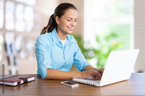 Happy Business Lady Using Laptop Posing Sitting At Workplace In Modern Office. Successful Entrepreneurship And Career Concept