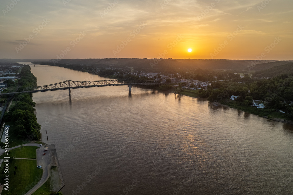 Sunset Over River with Small Town and Bridge